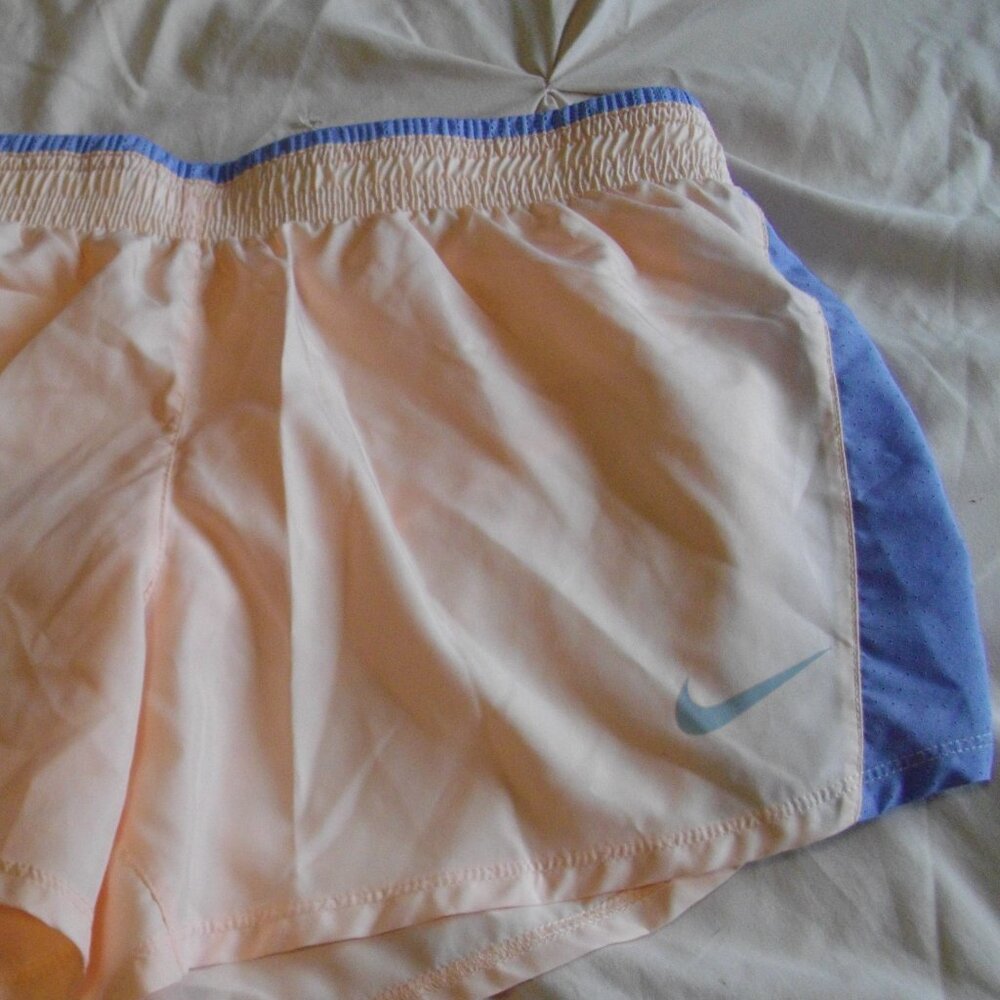 Nike Dri-Fit women's running shorts, Medium. Peach with blue mesh inset.